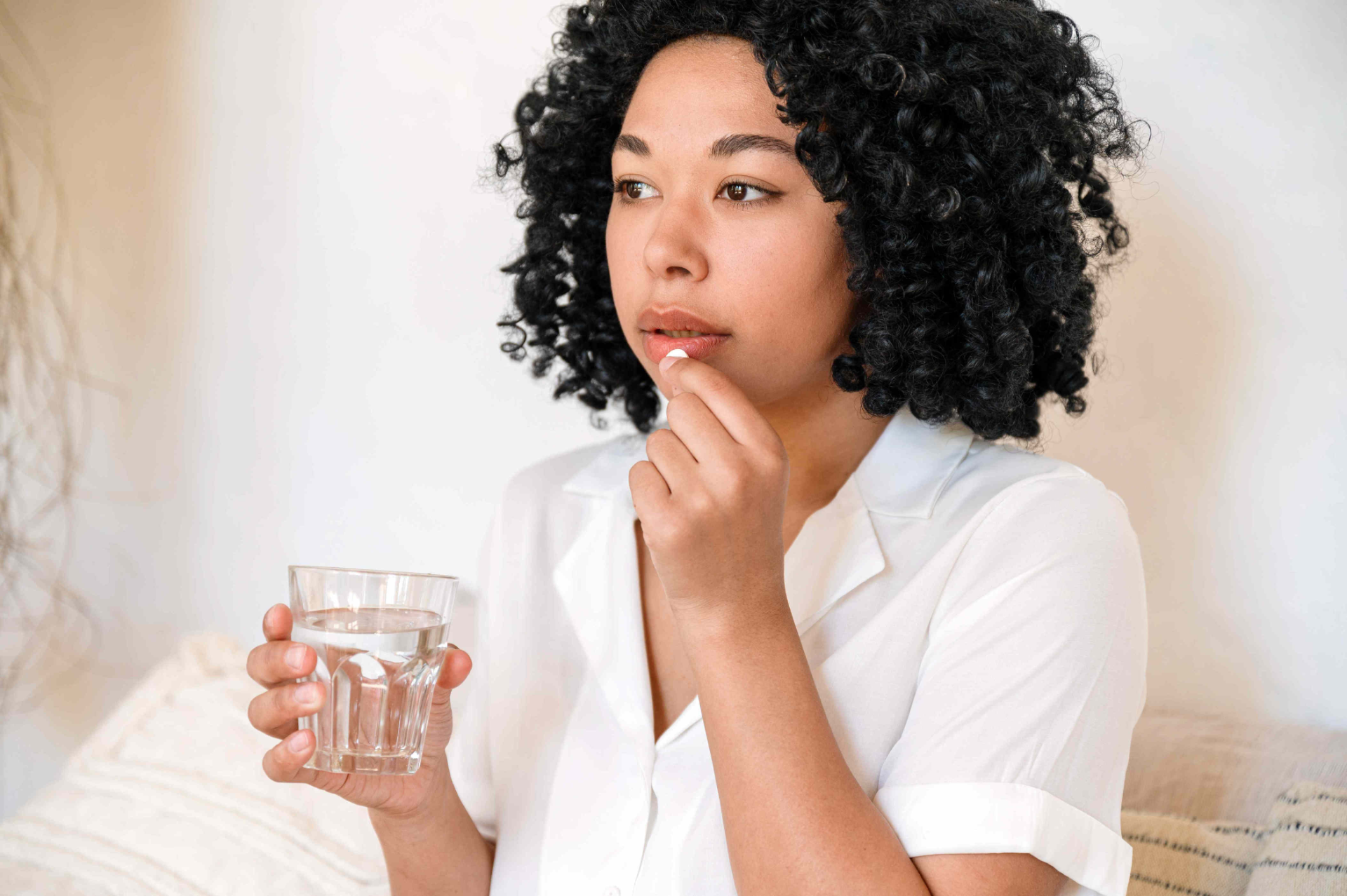 Woman seated while taking medication as part of a prescribed treatment plan to support her ongoing mental health and wellness